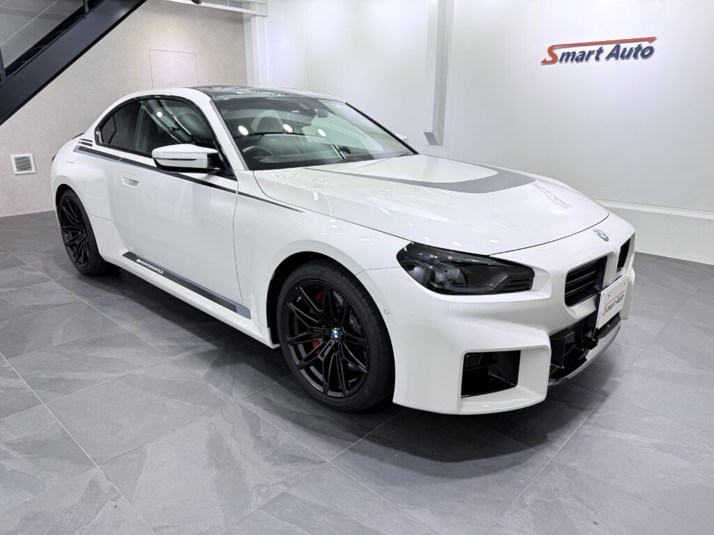 この度、当店に入庫いたしました G87型 BMW M2 クーペ は、スポーツカーの走りを存分に楽しめる6速マニュアルトランスミッション仕様で、アルピンホワイトⅢの鮮やかなボディカラーが際立つスタイリッシュなクーペです。
